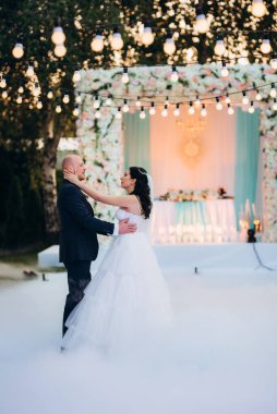 Gelin ve damadın ilk dansı açık hava restoranında ağır beyaz dumanla