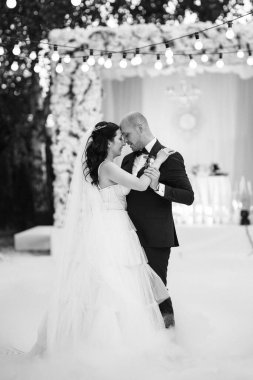 Gelin ve damadın ilk dansı açık hava restoranında ağır beyaz dumanla