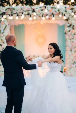 Gelin ve damadın ilk dansı açık hava restoranında ağır beyaz dumanla