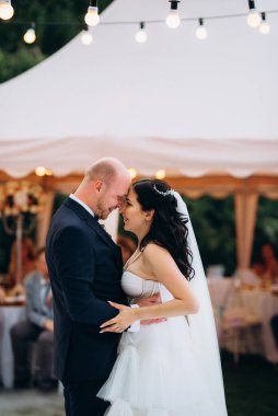 Gelin ve damadın ilk dansı açık hava restoranında ağır beyaz dumanla