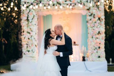 Gelin ve damadın ilk dansı açık hava restoranında ağır beyaz dumanla