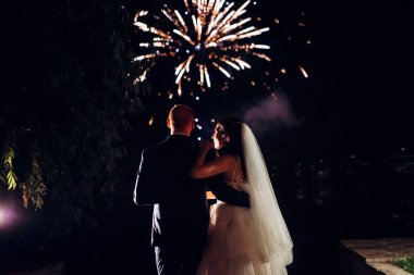 Karanlık bir gökyüzüne ve fırtınalara karşı bir ateş gösterisinin ateşli parçaları.