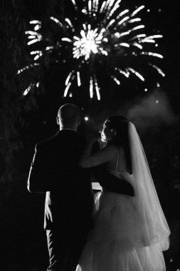 Karanlık bir gökyüzüne ve fırtınalara karşı bir ateş gösterisinin ateşli parçaları.