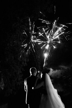 Karanlık bir gökyüzüne ve fırtınalara karşı bir ateş gösterisinin ateşli parçaları.