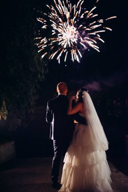 Karanlık bir gökyüzüne ve fırtınalara karşı bir ateş gösterisinin ateşli parçaları.