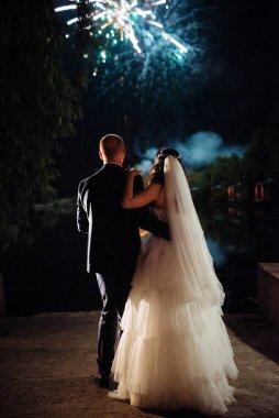 Karanlık bir gökyüzüne ve fırtınalara karşı bir ateş gösterisinin ateşli parçaları.