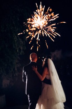 Karanlık bir gökyüzüne ve fırtınalara karşı bir ateş gösterisinin ateşli parçaları.