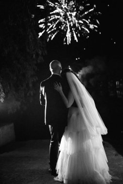 Karanlık bir gökyüzüne ve fırtınalara karşı bir ateş gösterisinin ateşli parçaları.