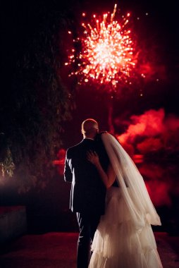 Karanlık bir gökyüzüne ve fırtınalara karşı bir ateş gösterisinin ateşli parçaları.