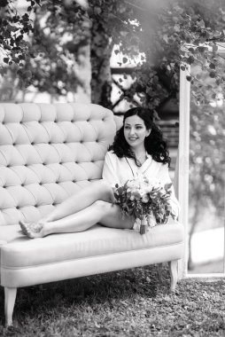 Siyah saçlı gelin evlenmeye hazırlanıyor. Bahçedeki bir yatak odasında.