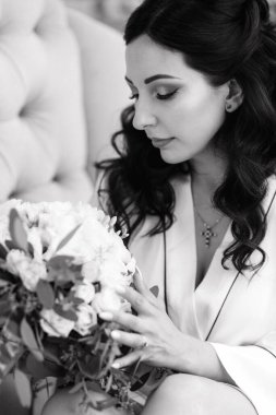 Siyah saçlı gelin evlenmeye hazırlanıyor. Bahçedeki bir yatak odasında.