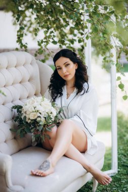 Siyah saçlı gelin evlenmeye hazırlanıyor. Bahçedeki bir yatak odasında.