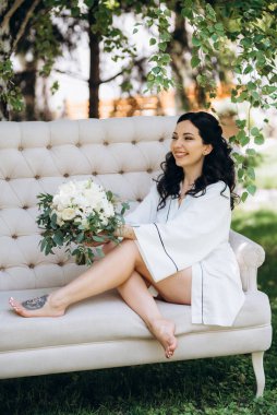 Siyah saçlı gelin evlenmeye hazırlanıyor. Bahçedeki bir yatak odasında.