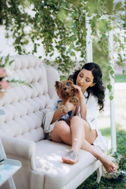 Siyah saçlı gelin evlenmeye hazırlanıyor. Bahçedeki bir yatak odasında.