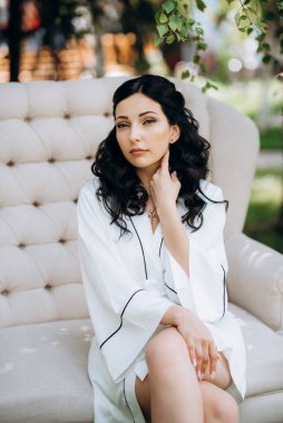 Siyah saçlı gelin evlenmeye hazırlanıyor. Bahçedeki bir yatak odasında.