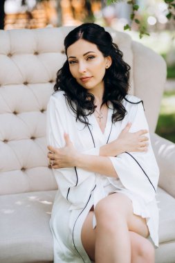 Siyah saçlı gelin evlenmeye hazırlanıyor. Bahçedeki bir yatak odasında.