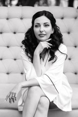 Siyah saçlı gelin evlenmeye hazırlanıyor. Bahçedeki bir yatak odasında.