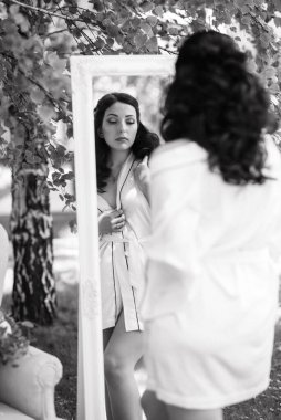 Siyah saçlı gelin evlenmeye hazırlanıyor. Bahçedeki bir yatak odasında.