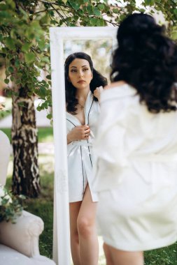 Siyah saçlı gelin evlenmeye hazırlanıyor. Bahçedeki bir yatak odasında.