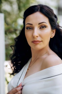 Siyah saçlı gelin evlenmeye hazırlanıyor. Bahçedeki bir yatak odasında.