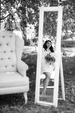 Siyah saçlı gelin evlenmeye hazırlanıyor. Bahçedeki bir yatak odasında.