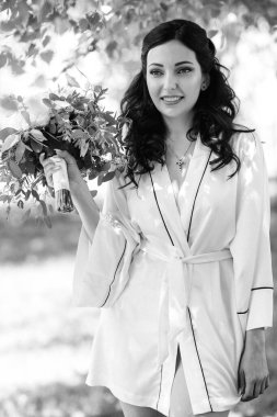 Siyah saçlı gelin evlenmeye hazırlanıyor. Bahçedeki bir yatak odasında.