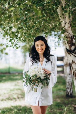 Siyah saçlı gelin evlenmeye hazırlanıyor. Bahçedeki bir yatak odasında.