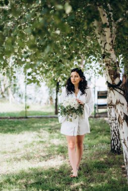 Siyah saçlı gelin evlenmeye hazırlanıyor. Bahçedeki bir yatak odasında.