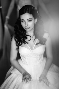 portrait of a bride in the morning before the wedding with putting on a white dress