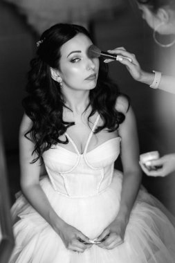 portrait of a bride in the morning before the wedding with putting on a white dress