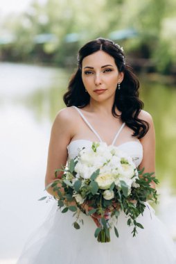 Gelin, sarı bir günbatımının arka planında nehir kıyısındaki bir iskelede