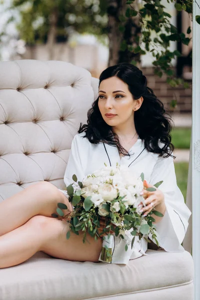 Siyah saçlı gelin evlenmeye hazırlanıyor. Bahçedeki bir yatak odasında.