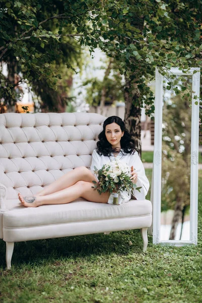 Siyah saçlı gelin evlenmeye hazırlanıyor. Bahçedeki bir yatak odasında.