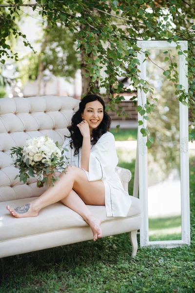 Siyah saçlı gelin evlenmeye hazırlanıyor. Bahçedeki bir yatak odasında.