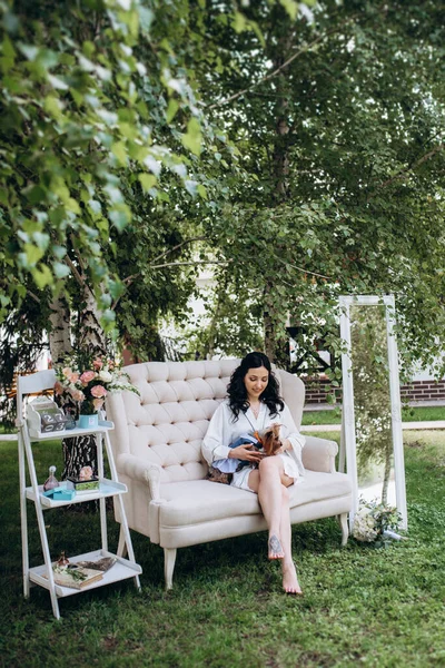 Siyah saçlı gelin evlenmeye hazırlanıyor. Bahçedeki bir yatak odasında.