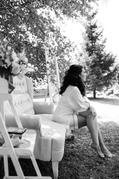 Siyah saçlı gelin evlenmeye hazırlanıyor. Bahçedeki bir yatak odasında.