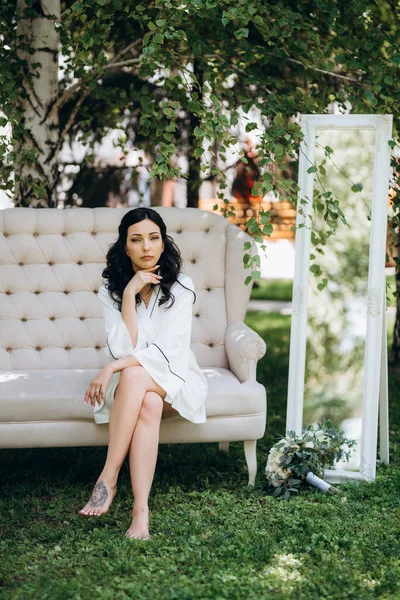 Siyah saçlı gelin evlenmeye hazırlanıyor. Bahçedeki bir yatak odasında.