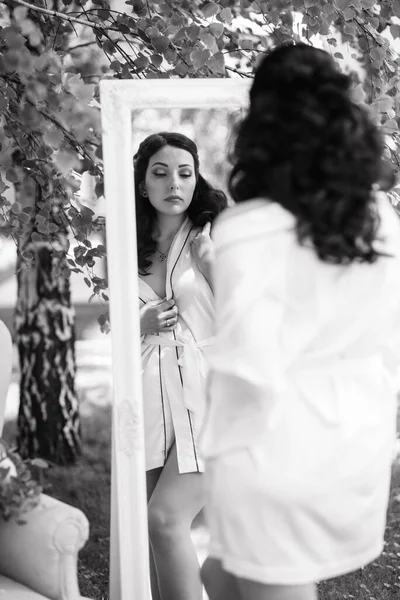 Siyah saçlı gelin evlenmeye hazırlanıyor. Bahçedeki bir yatak odasında.