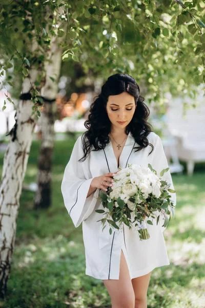 Siyah saçlı gelin evlenmeye hazırlanıyor. Bahçedeki bir yatak odasında.