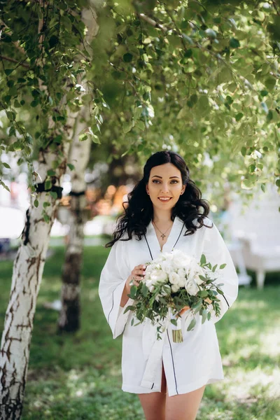 Siyah saçlı gelin evlenmeye hazırlanıyor. Bahçedeki bir yatak odasında.