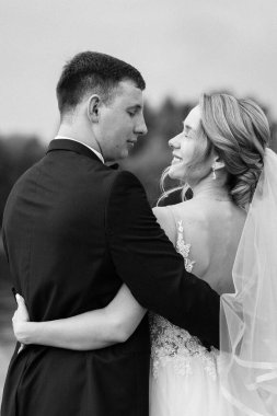 Genç çift, gelin ve damat, nehir kıyısında yürüyorlar.