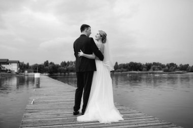 Genç çift, gelin ve damat, nehir kıyısında yürüyorlar.