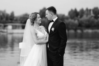 Genç çift, gelin ve damat, nehir kıyısında yürüyorlar.