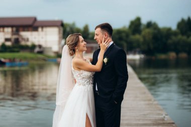 Genç çift, gelin ve damat, nehir kıyısında yürüyorlar.