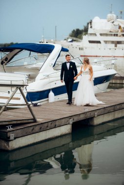 Genç çift, gelin ve damat, nehir kıyısında yürüyorlar.