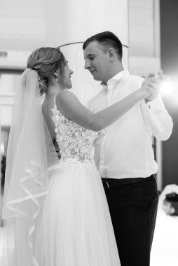 Gelin ve damadın ilk düğün dansı gün batımında restoranın içinde.