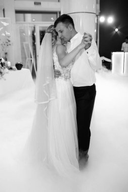 Gelin ve damadın ilk düğün dansı gün batımında restoranın içinde.