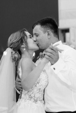 Gelin ve damadın ilk düğün dansı gün batımında restoranın içinde.