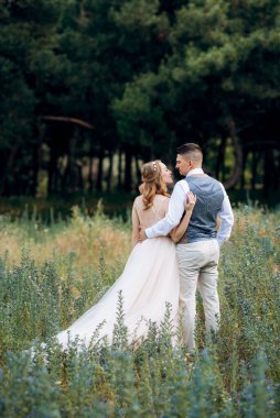 Gelin ve damat parklarda yürüyorlar patikalar boyunca ve ışık huzmeleri içinde