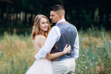 Gelin ve damat parklarda yürüyorlar patikalar boyunca ve ışık huzmeleri içinde